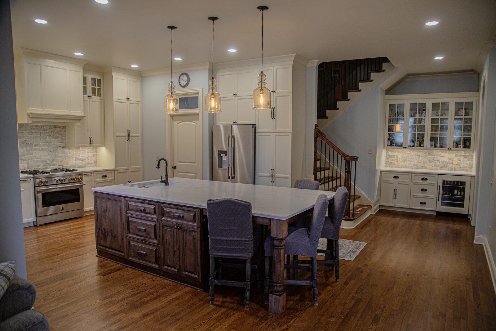 Classic white kitchen with walnut island and open staircase